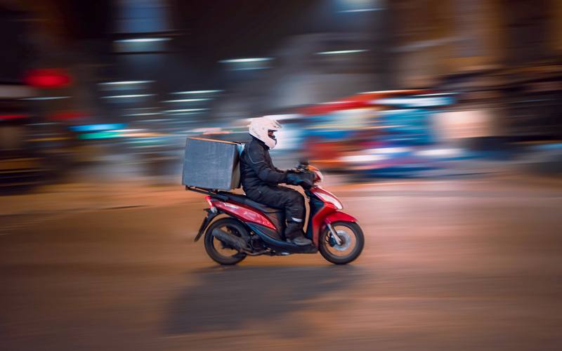 Livreur indépendant à scooter la nuit à Toulouse